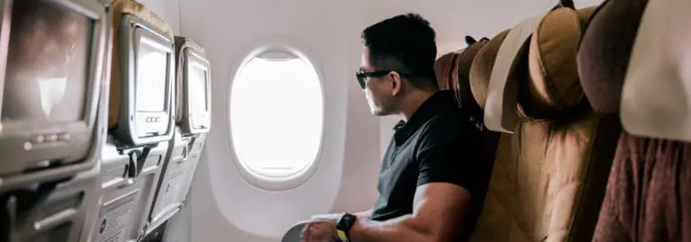 man looking outside airplane window