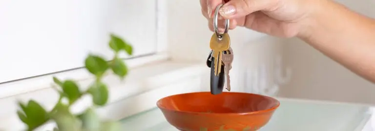 woman putting house keys near doorway