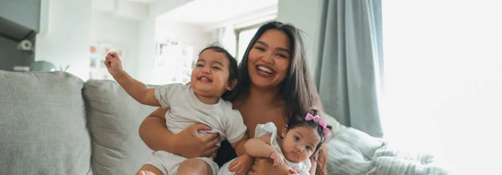 mother holding her two children at home