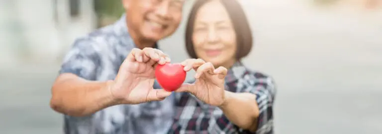 senior couple holding a red heart