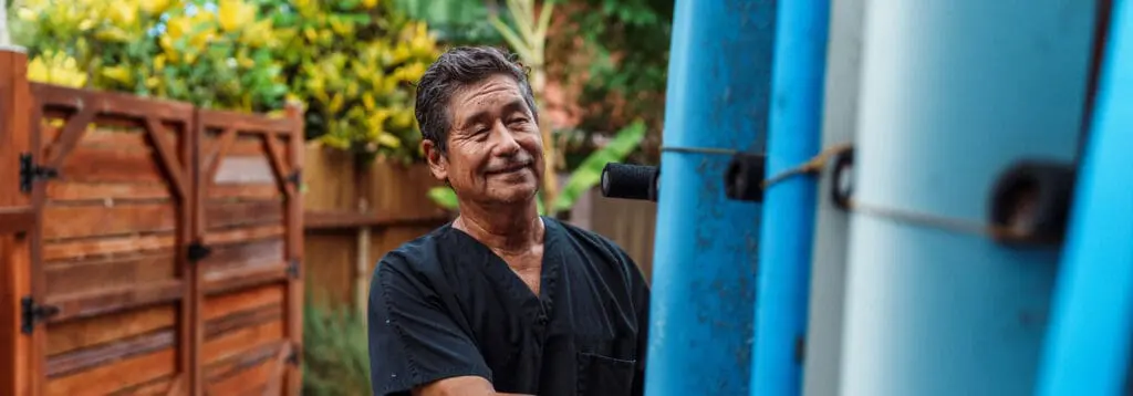 senior man examining surfboards