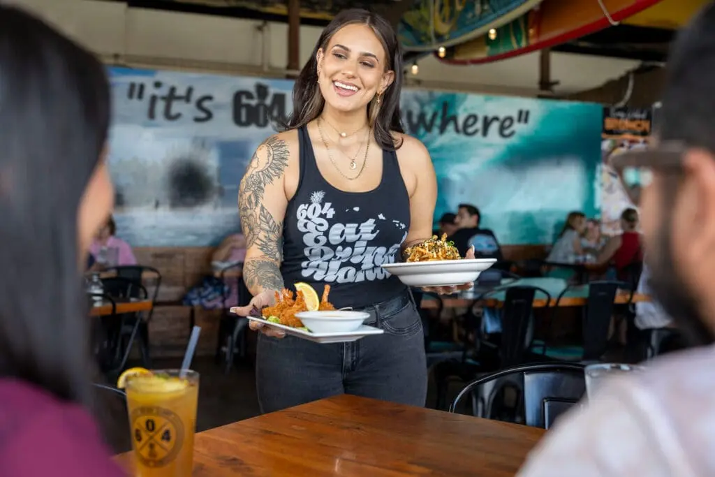 server serving food to couple at restaurant