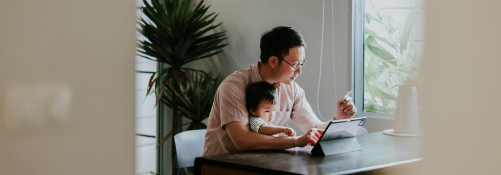 father and son looking at computer at home