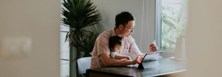 father and son looking at computer at home